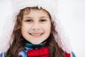 Funny cute girl laughing outdoors in winter day. Pretty little girl smiling with long hair in red hat and scarf standing Royalty Free Stock Photo