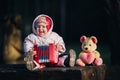 Funny cute girl, a small child in fashionable jeans plays the accordion. Happy baby plays the game. Cute adorable baby Royalty Free Stock Photo