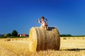 Funny cute little girl posing on the haystack in summer field Royalty Free Stock Photo