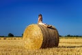 Funny cute little girl posing on the haystack in summer field Royalty Free Stock Photo