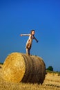 Funny cute little girl posing on the haystack in summer field Royalty Free Stock Photo