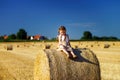 Funny cute little girl posing on the haystack in summer field Royalty Free Stock Photo