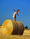 Funny cute little girl posing on the haystack in summer field Royalty Free Stock Photo