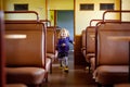 Funny cute little girl running through an empty train waggon. Happy healthy toddler child having fun on family travel