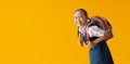 Funny cute smiling schoolgirl in uniform, isolated on yellow background Royalty Free Stock Photo