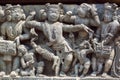 Funny dancing people in traditional Indian clothes. Relief of 12th century Hindu temple Hoysaleshwara in Halebidu, India Royalty Free Stock Photo