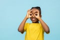 Funny dark- skinned little boy looking with hands binoculars Royalty Free Stock Photo