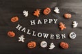 Funny delicious ginger cookies for Halloween on a dark wooden table. Top view. Inscription Happy Halloween, sweet background