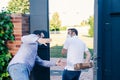 Funny delivery man delivering package to customer from behind his back