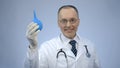 Funny doctor holding rectal syringe with smile on face, proctologist joking