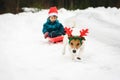 Funny dog with Rudolph reindeer`s antlers pulls sled with Santa Claus Royalty Free Stock Photo