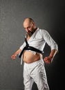 Funny drunken fat karateka in small kimono and with black belt with a big belly Royalty Free Stock Photo