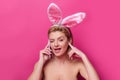 Funny Easter bunny woman calling with cell phone.