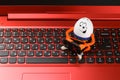Funny Easter egg working on a red notebook computer Royalty Free Stock Photo