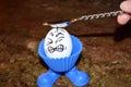 Funny egg with a painful expression as he is hit on the head with a spoon