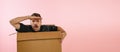 Funny emotive man sitting inside carton box and looking for big sales isolated on pink background. Black Friday Royalty Free Stock Photo