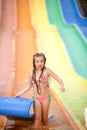 Funny excited child enjoying summer vacation in water park