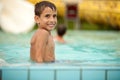 Funny excited child enjoying summer vacation in water park