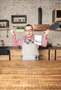 Funny excited man wearing pinafore with kitchen utensils