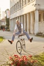 Funny expression legs spread, one young man, 20-29 years old, wearing hipster suit, smart casual, riding cycling old city bike Royalty Free Stock Photo