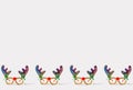 Funny eyeglasses with shape of the reindeer antlers made of colorful shiny tinsels on white background