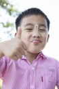 Funny face of asian children eating milk icecream in tea spoon in mouth