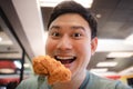 Funny face Asian man eat fried chicken Royalty Free Stock Photo