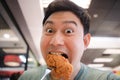 Funny face Asian man eat fried chicken Royalty Free Stock Photo