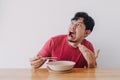 Funny face of man eat very hot and spicy instant noodle. Royalty Free Stock Photo