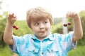 Funny face. Baby child with cherries in two hands. Fun math. Equations. Summer holidays. Happy time. Garden with fruit Royalty Free Stock Photo