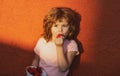 Funny face of cute little boy eating a strawberry. Royalty Free Stock Photo