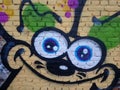 Funny face drawing on the wall, graffiti in the background. Royalty Free Stock Photo