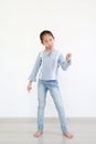 Funny face expression asian little child girl in white room. Full length Royalty Free Stock Photo