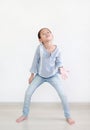 Funny face expression asian little child girl in white room. Full length Royalty Free Stock Photo