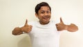 Funny face expression of young Asian Malay man in white t-shirt showing double thumbs up Royalty Free Stock Photo