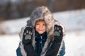 Funny face of little boy on snow winter nature. Funny kid in winter clothes. Children play outdoors in snow. Kids Royalty Free Stock Photo