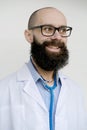 Funny face of male charismatic doctor in uniform in white coat with medical instrument stethoscope, young bearded pensive man