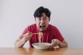 Funny face of man eat very hot and spicy instant noodle. Royalty Free Stock Photo