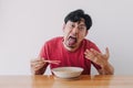 Funny face of man eat very hot and spicy instant noodle. Royalty Free Stock Photo