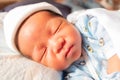 The funny face of sleeping newborn baby infant on the bed in the morning Royalty Free Stock Photo