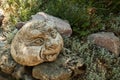 Funny face among stones and grass. Garden sculpture. Japanese garden. Royalty Free Stock Photo