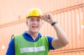 Funny factory worker man in hard hat smiling and looking at camera with joy, Happiness engineer at cargo containers concept Royalty Free Stock Photo