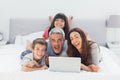 Funny family lying on bed using their laptop Royalty Free Stock Photo