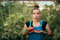 Funny Farm Girl Comparing a Big Tomato to a Small One Royalty Free Stock Photo