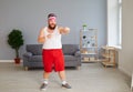 Funny fat boxer in sportswear is boxing in the room. Royalty Free Stock Photo