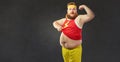 A funny fat man with a big belly shows the muscles on his arm. Royalty Free Stock Photo