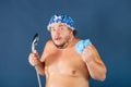 Funny fat man in blue cap sing in the shower Royalty Free Stock Photo