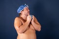 Funny fat man in blue cap sing in the shower Royalty Free Stock Photo