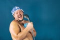 Funny fat man in blue cap sing in the shower Royalty Free Stock Photo