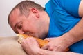 A funny fat man in a blue t-shirt sleeps after training, kissing a bitten-off loaf. home fitness training, self-training